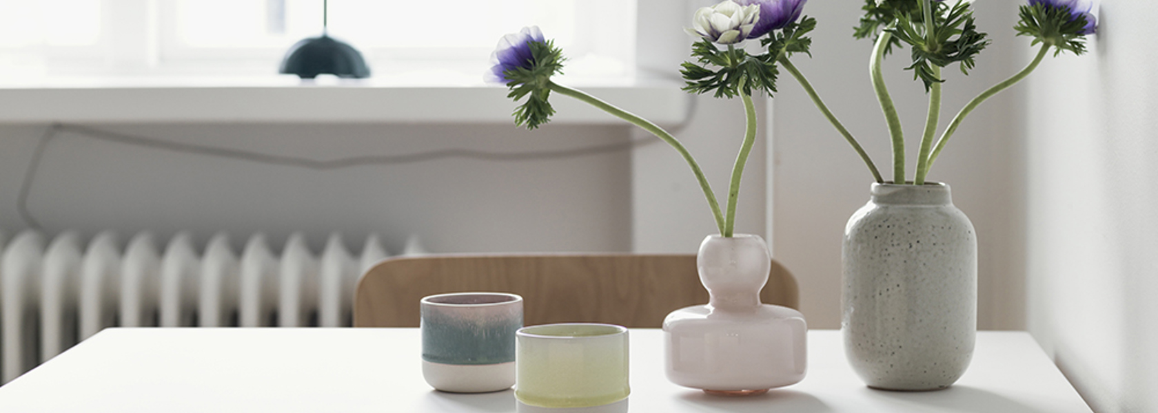 Matplats med ett litet bord och två stolar i närbild med vaser och blommor som dekoration. 