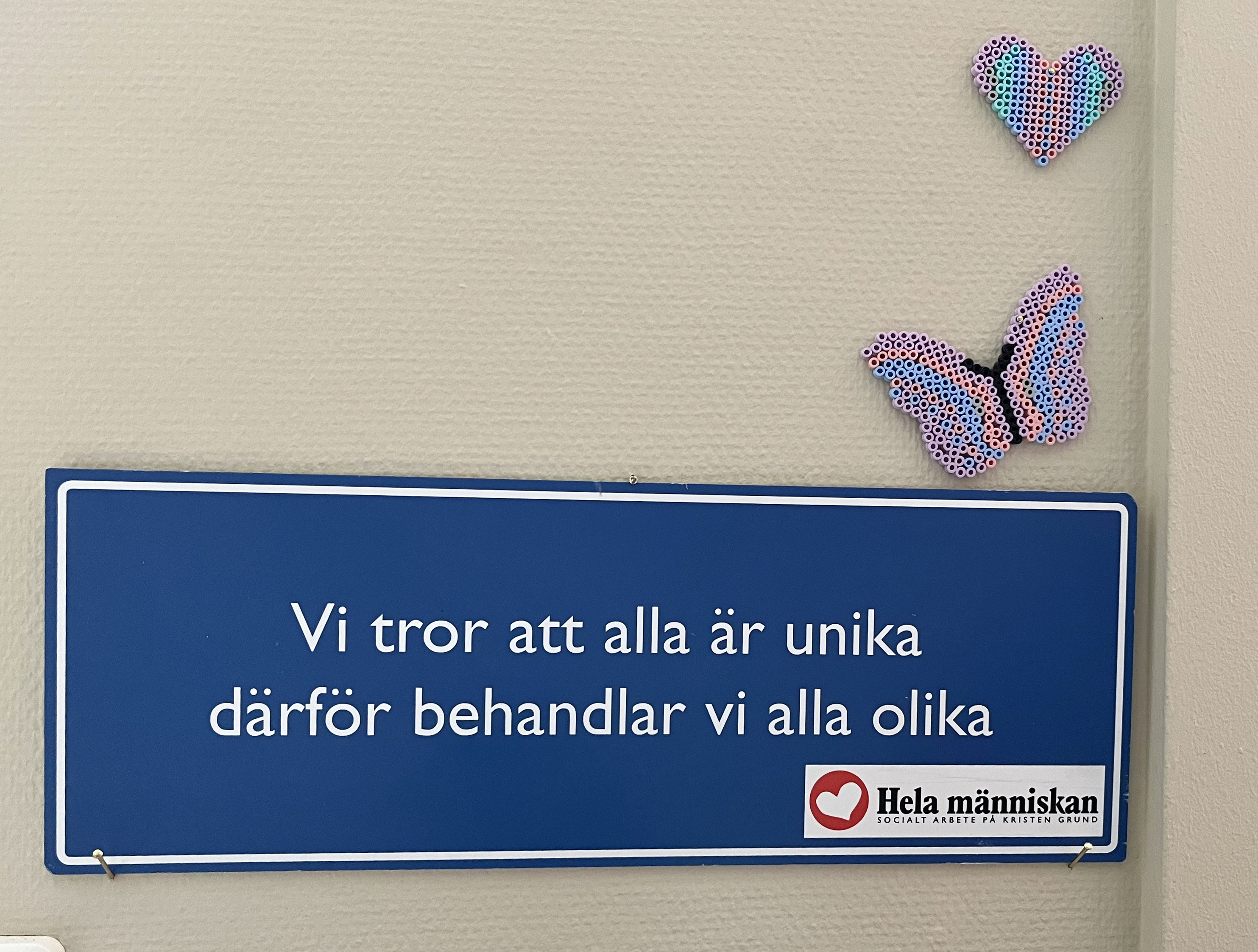 En skylt med en text där det står Vi tror alla är unika därför behandlar vi alla olika. 